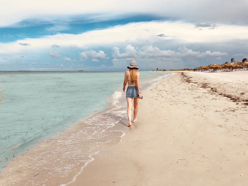 Back View Photo of Women Walking by the Beach