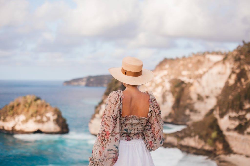 Trendy woman in hat admiring rocky cliffs