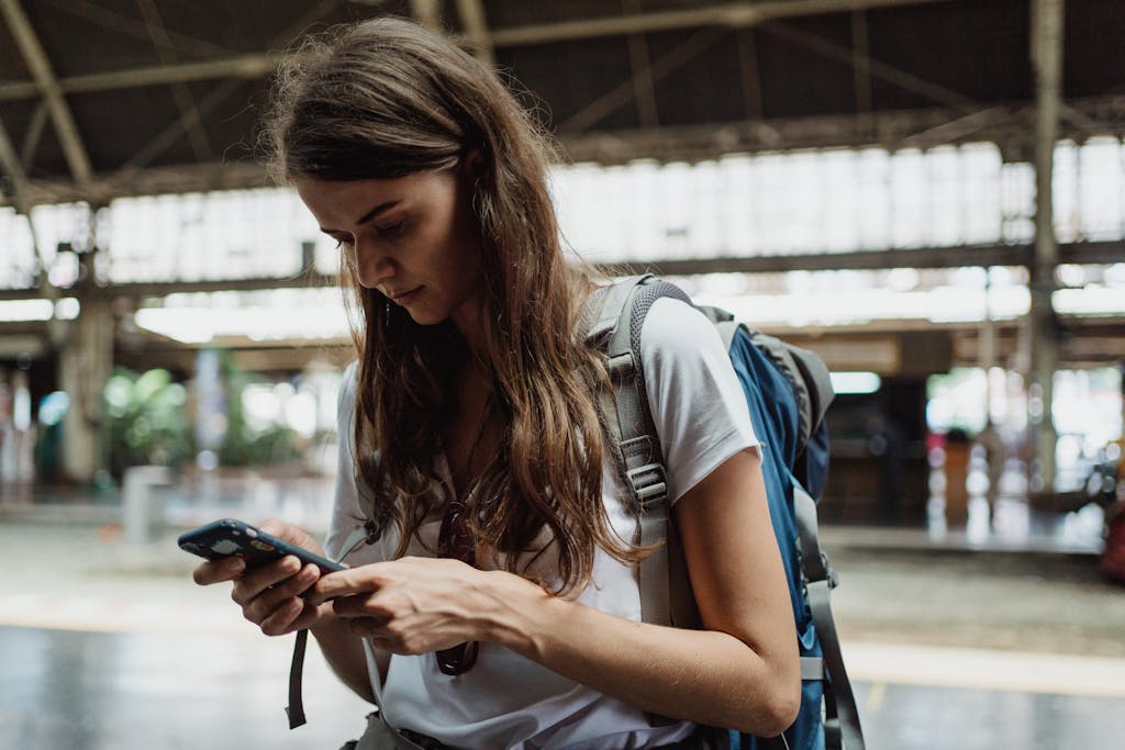 Woman in White Neck T-shirt Using Smartphone