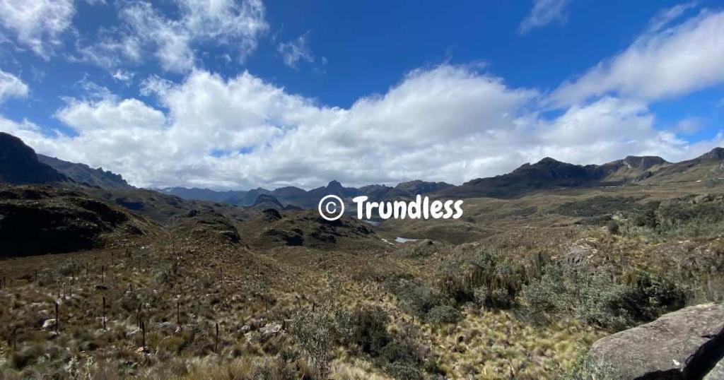 A panoramic view of a mountainous landscape in Ecuador, with grassy terrain under a partly cloudy blue sky, captures the enticing allure of a potential permanent residence.