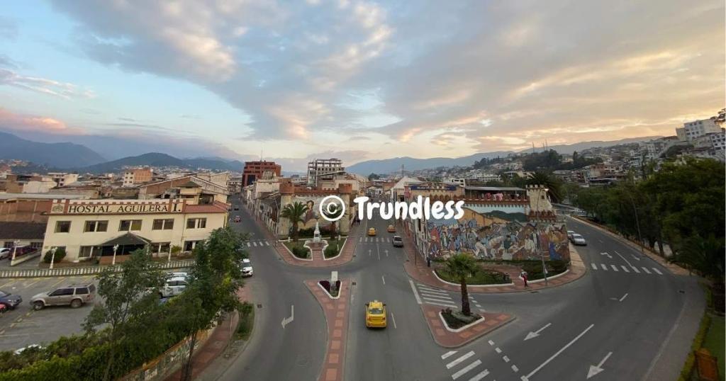 Aerial view of the city Loja Ecuador and an intersection, where the promise of permanent residence blends seamlessly with the vibrant mural adorning one building. Photo by Trundless.com