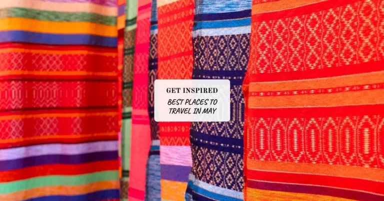 Colorful patterned fabrics are displayed vertically, with a white sign in the center reading "GET INSPIRED BEST PLACES TO TRAVEL IN MAY.